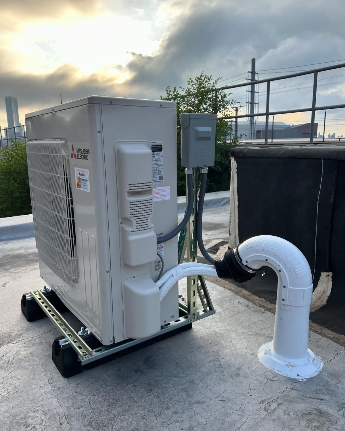 Mitsubishi Electric high-wall inverter condenser installed on a Gauteng rooftop at dusk.
